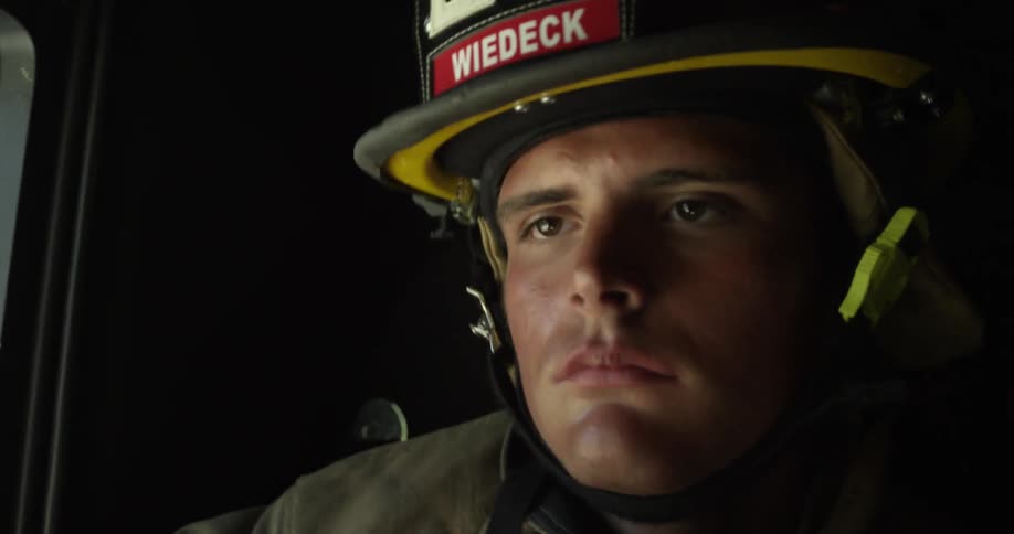 A fireman is sitting in a moving truck