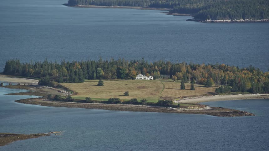 Aerial panorama of an island with only one residence surrounded by the sea