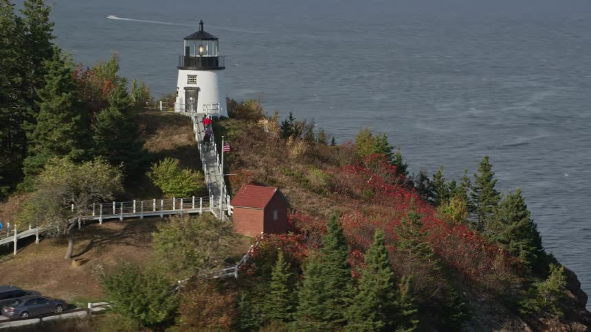 View of a fort on a coastal peak with people climbing