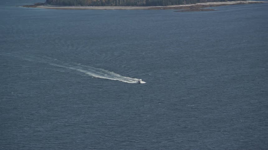 A boat sailing in the ocean near the shore of the beach