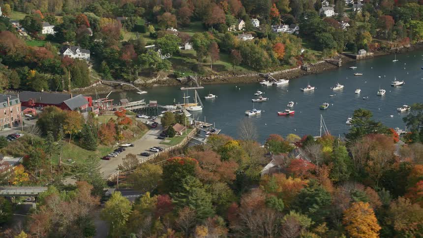 A residential area next to a large river with many boats sailing on the water