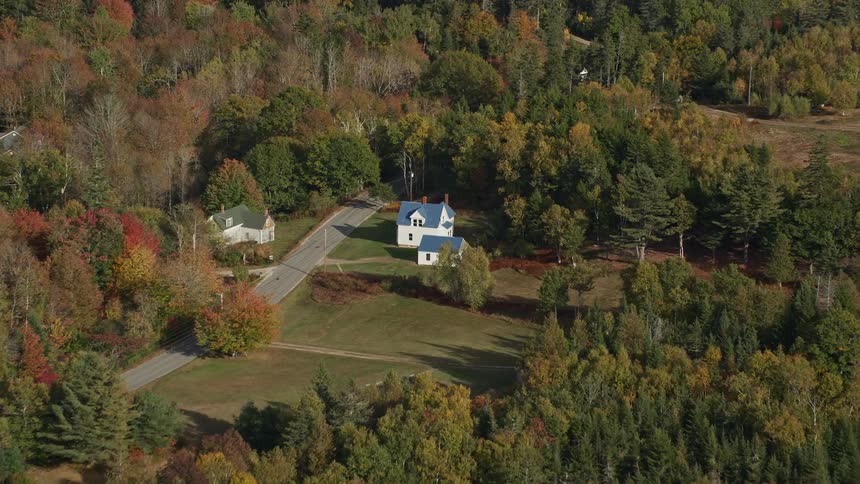 An aerial panorama of houses amidst forested areas