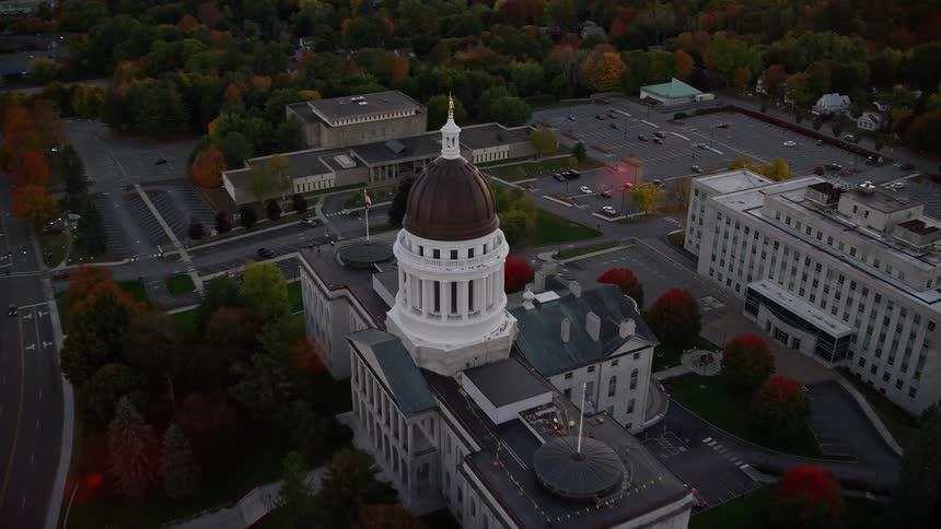 Trees with fall foliage surround town with domed government building
