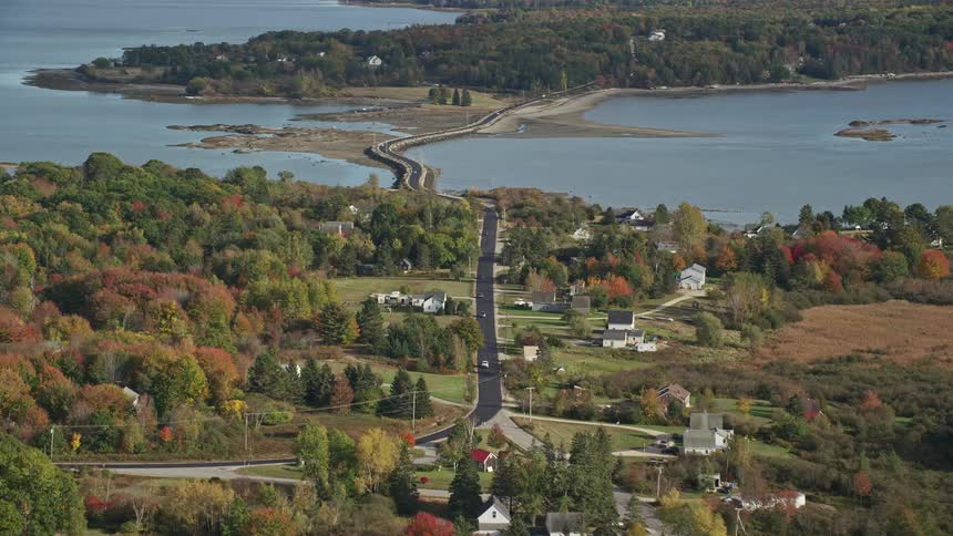 Aerial view of a bridge crossing a river next to a small town