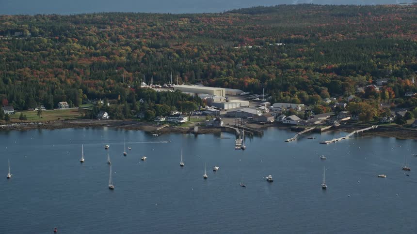 Aerial view of boats next to a pier in a small coastal town