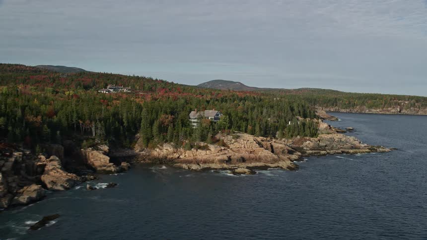 Aerial view of coastal homes and trees with fall color