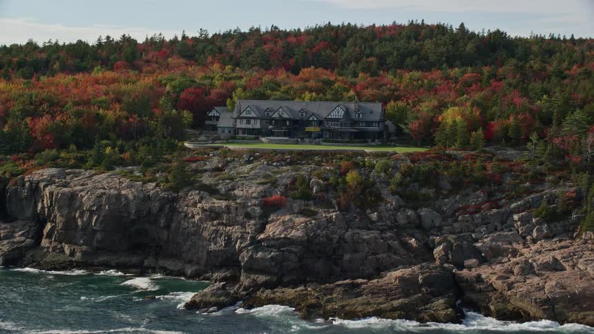 Aerial view of a mansion on a cliff next to the ocean