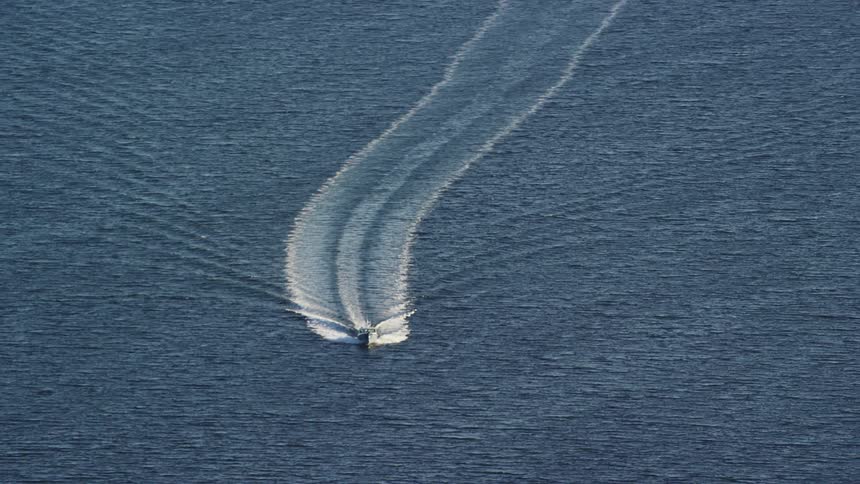 A speedboat sailing in the ocean on a sunny day