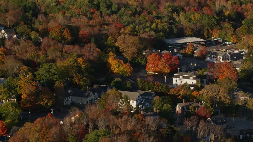 Trees with fall foliage dot wooded house lots surrounding church