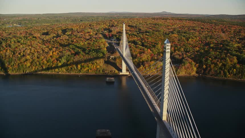 Aerial view of a suspension bridge over a river next to a small town