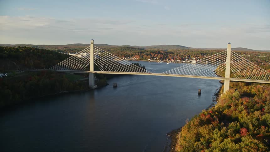 Aerial view of a suspension bridge over a river next to a small town