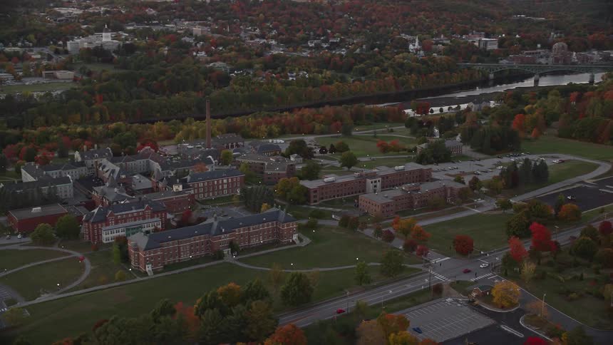 An aerial view of brown buildings in between the river and the highway