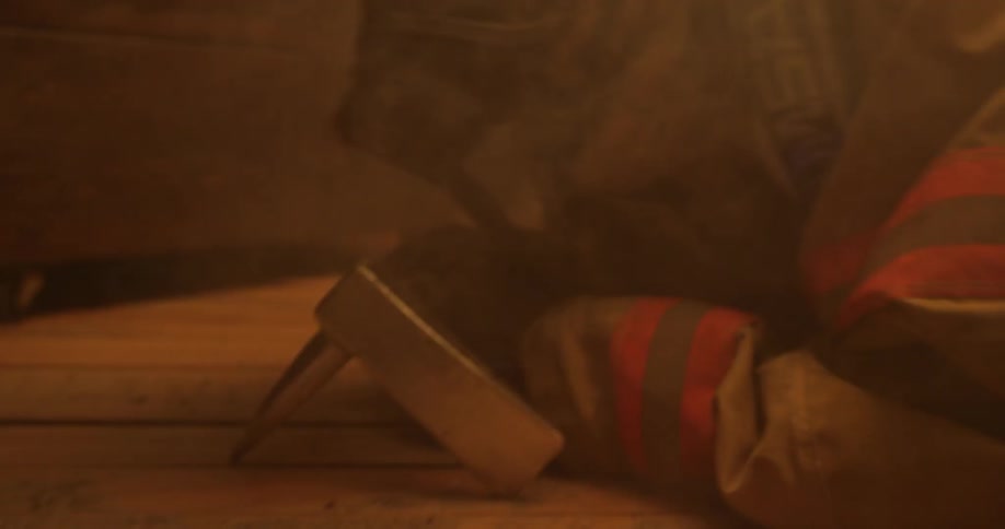 A firefighter is crawling through a burning home