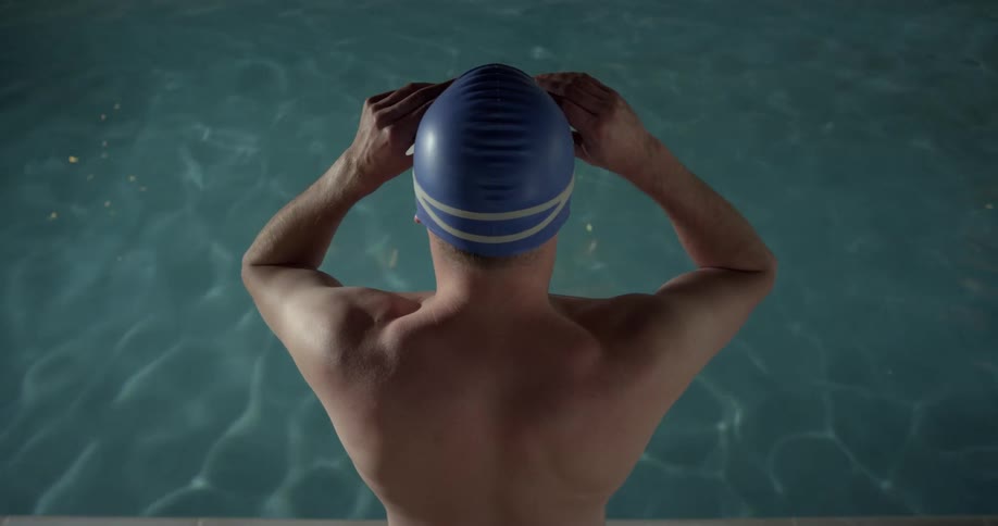 A swimmer standing in front of a pool of water