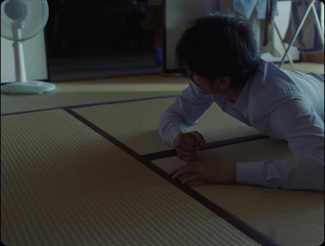 Father lying on floor turns his head to watch child leave room