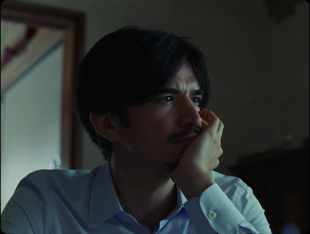 A thoughtful man sits looking into the distance