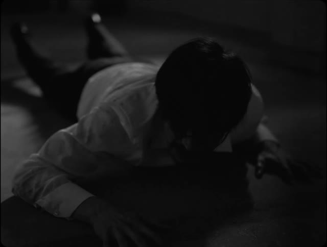 Man lying on his stomach on the floor raises his head to look around
