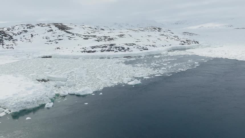 Aerial view of the arctic sea with snowcovered mountains and ice