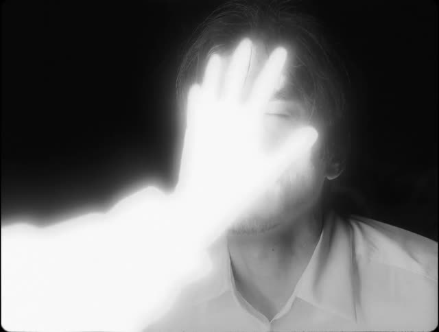 Male face is touched by ghostly hand