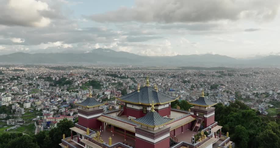 Aerial view of an asian temple on a hill with a suburb in the horizon