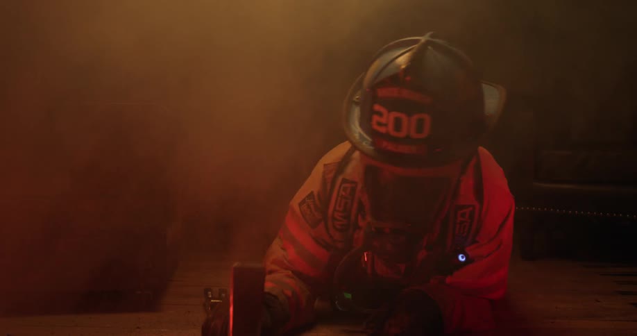 A fireman crawls along the floor