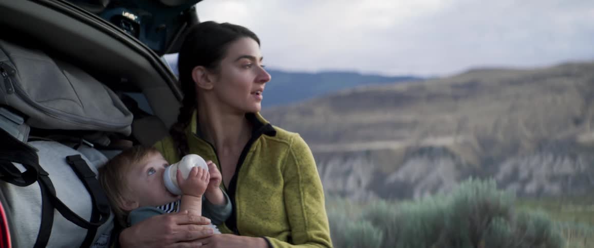Mother holding her baby while he drinks milk from a bottle