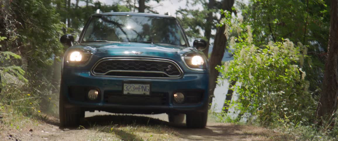 Blue vehicle climbing a small hill in the midst of nature