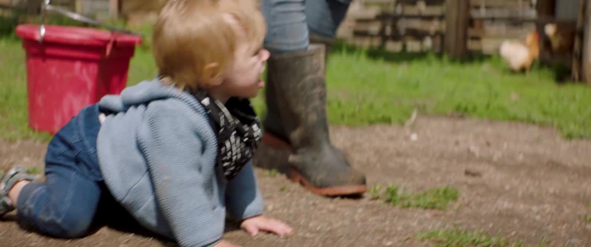 A mother follows her crawling son