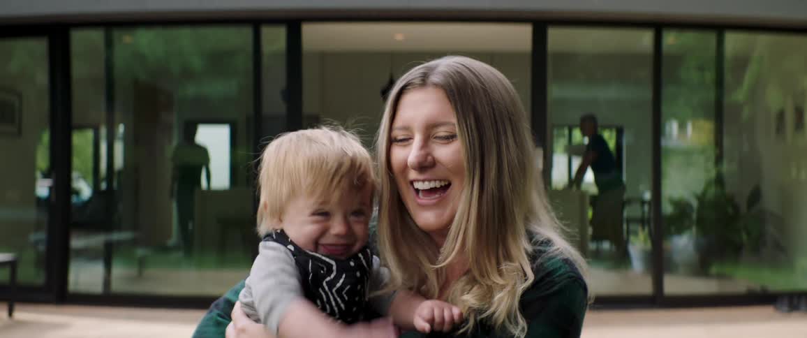 A mother and her son drink happily in the garden at home