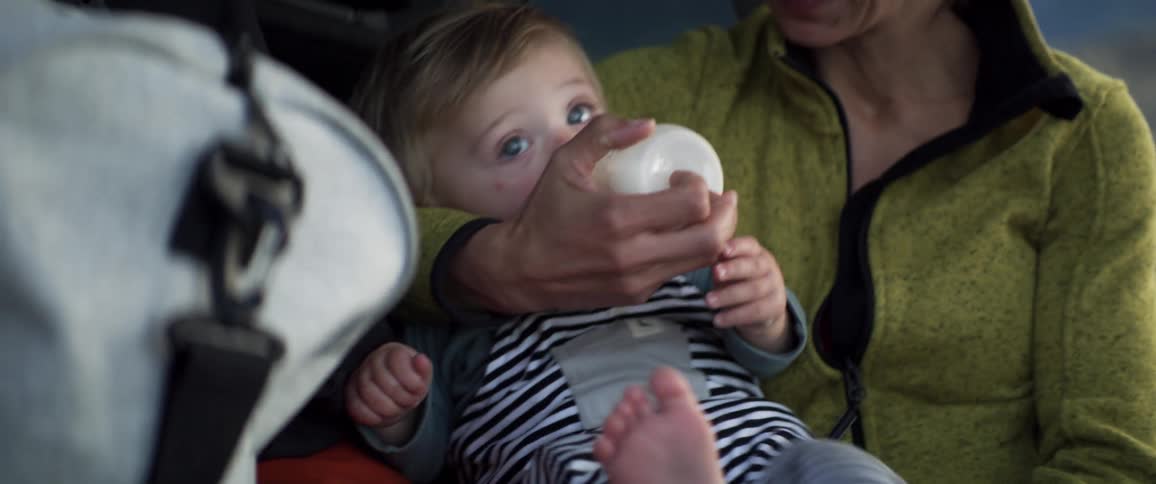 Parents park car in field to feed baby a bottle