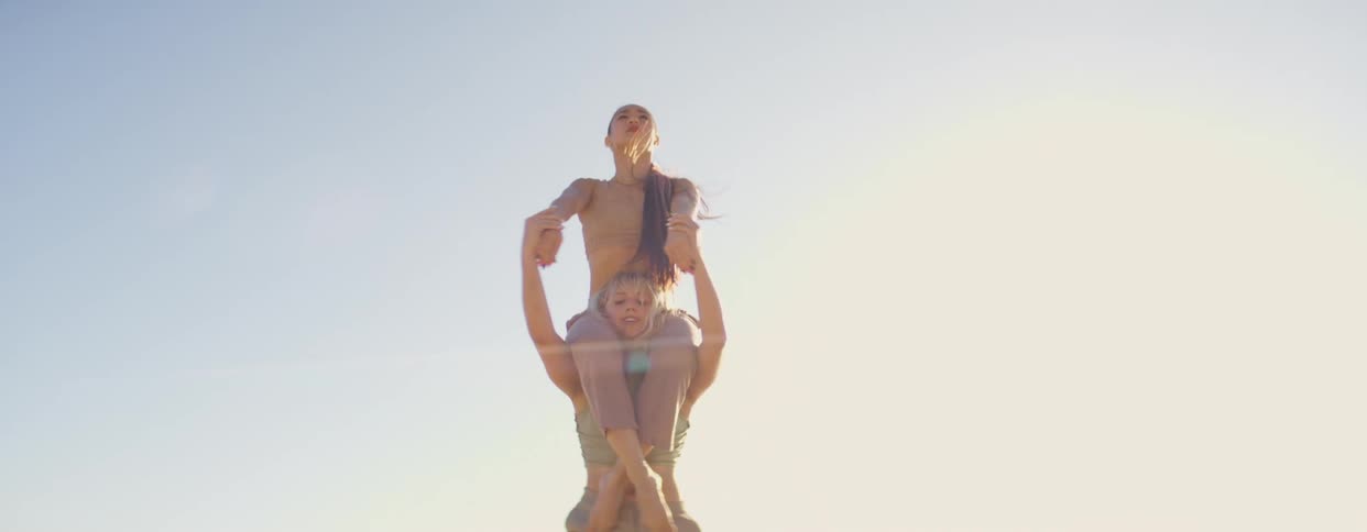 Two women dance near the ocean at daytime