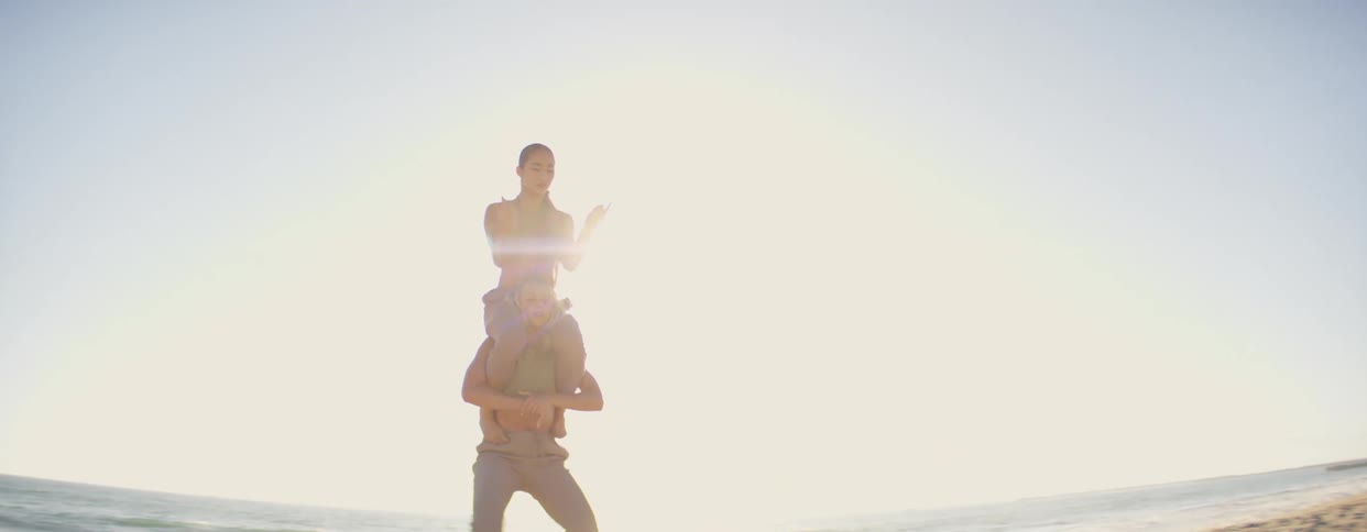 Two women gesture while dancing near the ocean at daytime