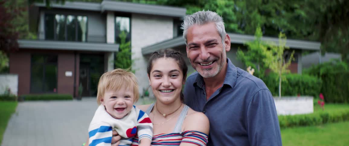 A family stand together smiling
