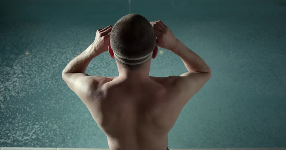A swimmer putting his goggles on