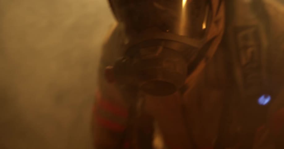 Oxygen wearing fireman crawls across floor in smokey room