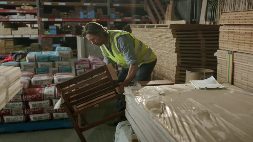 Hardware store worker checks merchandise against clipboard