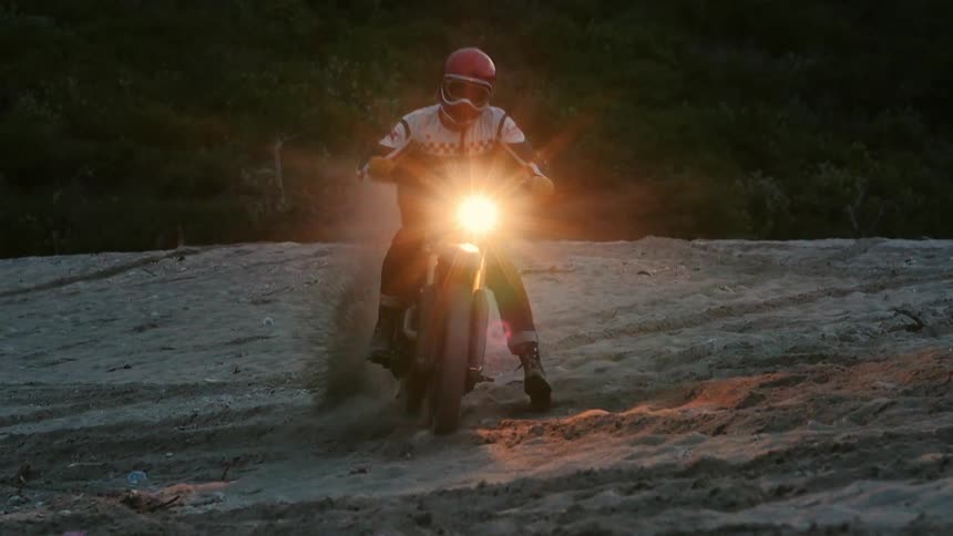 A man riding a dirt bike at sunset