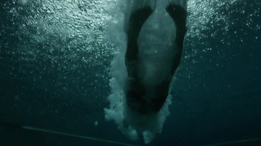 A diver diving into a body of water