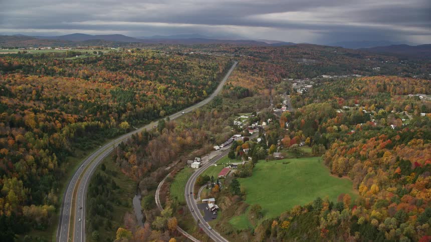 Vehicles drive past the town on the highway