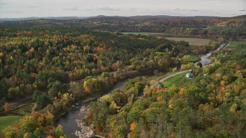 Aerial view of a rural area with lots of trees a river and scattered houses
