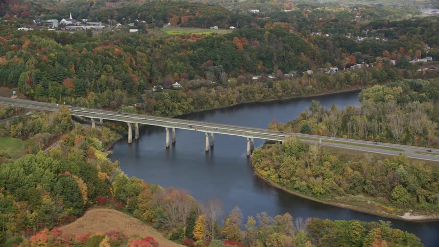 Aerial view of the woods in the fall with a river running through it