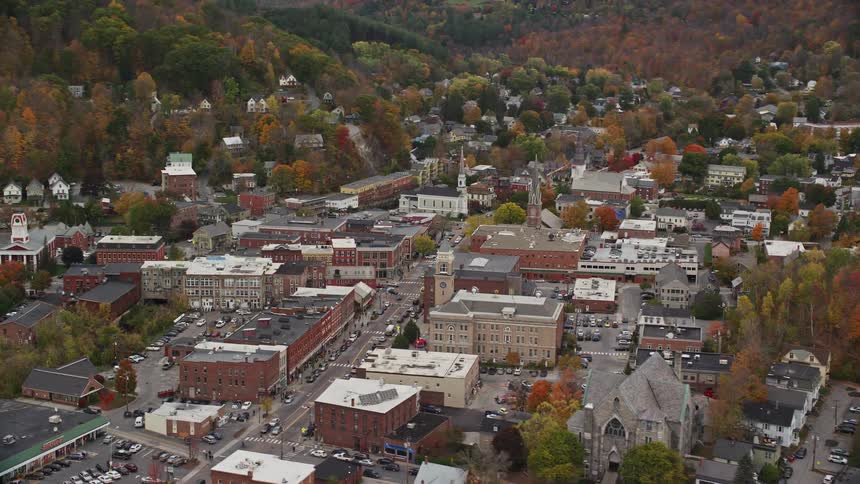View of an urban city amidst mountains and forests