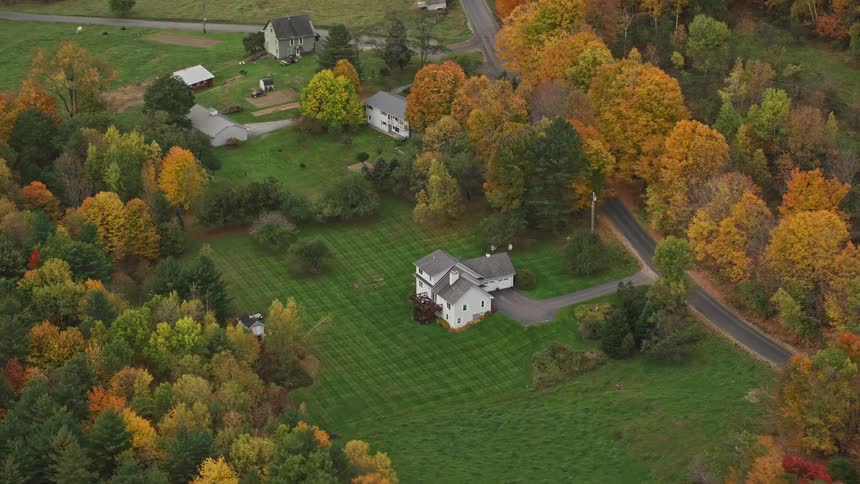 Aerial view of houses and farms in the fields at autumn