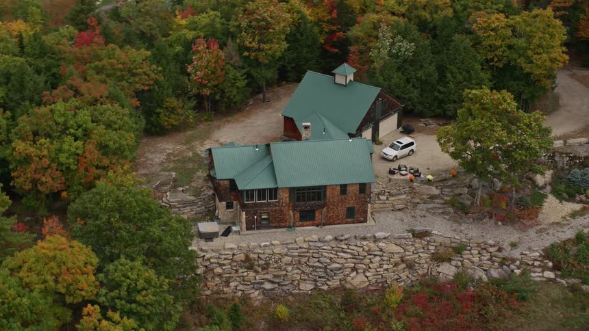 Aerial view of cabin with green roof in fall landscape