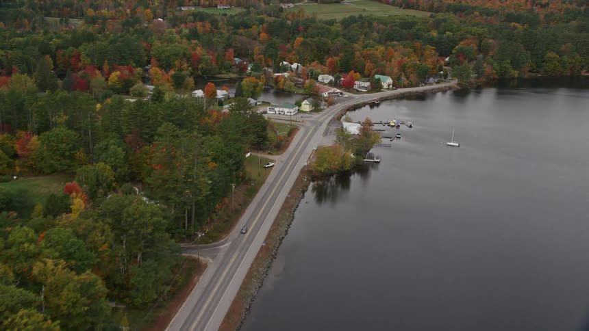 An aerial panorama of an urban city by the edge of a lake and amidst a forest