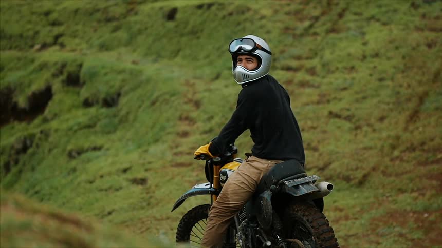A man is looking bike on a dirt bike