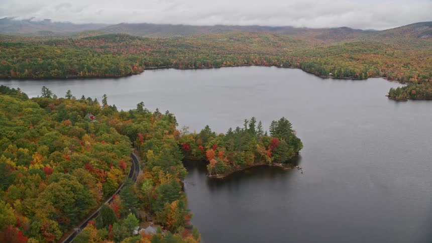 A large lake surrounded by forests and a road nearby