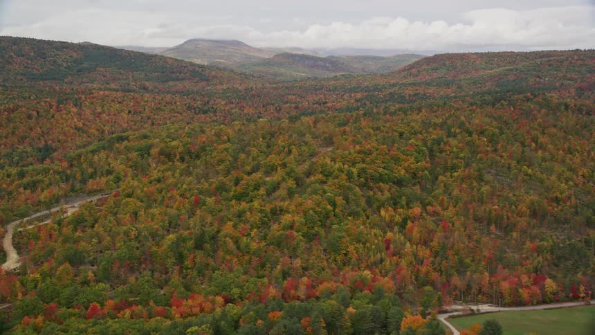 An aerial panorama of an area with mountains and forested woods