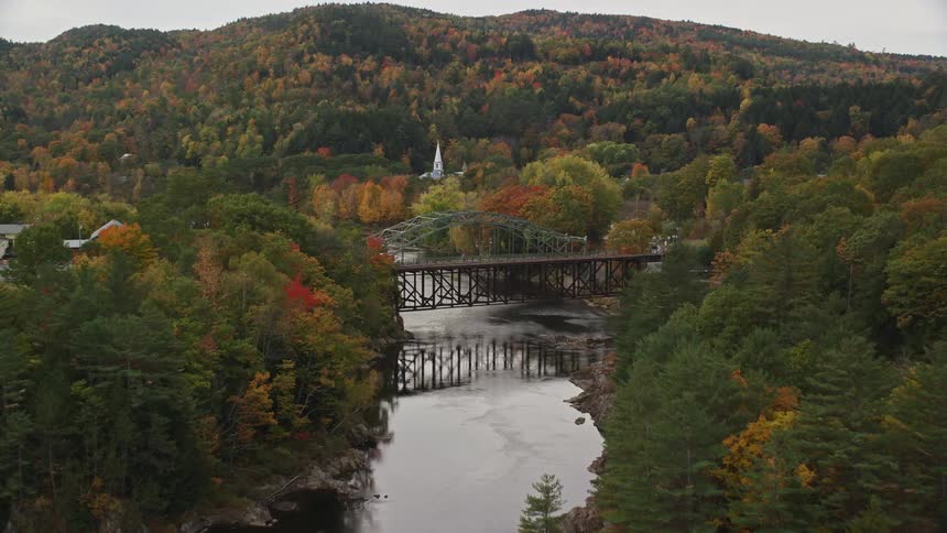 Aerial view of a heavily wooded area in the fall with a river running through it