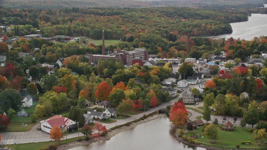 A sub urban town surrounded by trees and river